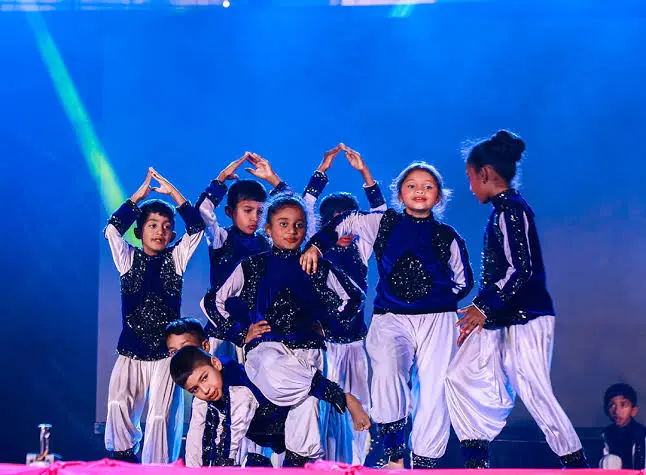Students performing on stage at Auxilium School Maradiyur cultural event
